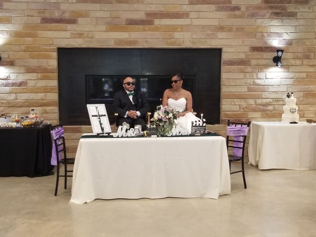 Scott and Kimberlyn at their sweetheart table in front of the stone fireplace