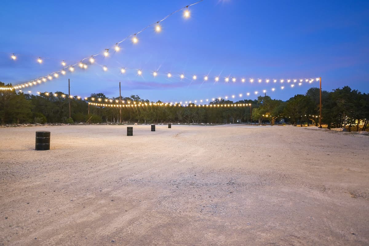 Prima Vista's on-site parking area illuminated by overhead lights at blue hour